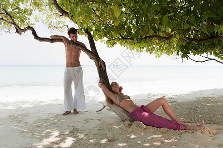 海滩树下聊天的情侣图片