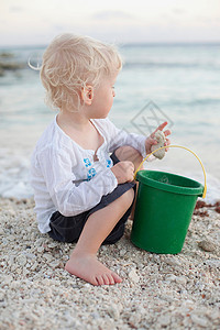 小男孩在海滩上玩沙图片