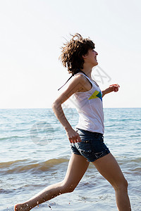 女人在海滩的浪中奔跑图片