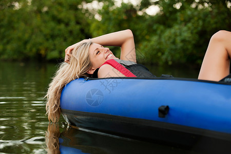 妇女在小溪的皮艇上放松图片