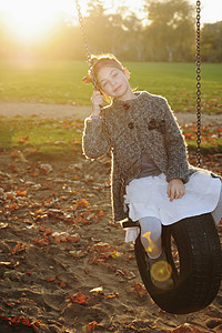 女孩在公园里玩轮胎秋千图片