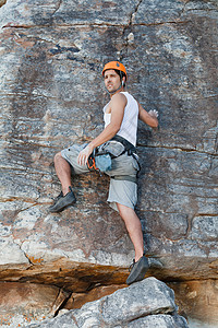 攀爬者徒手攀爬陡峭的岩石高清图片