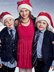 在雪中戴圣诞帽子的儿童图片