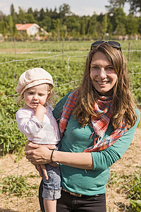 抱着女儿在草莓园的妇女图片