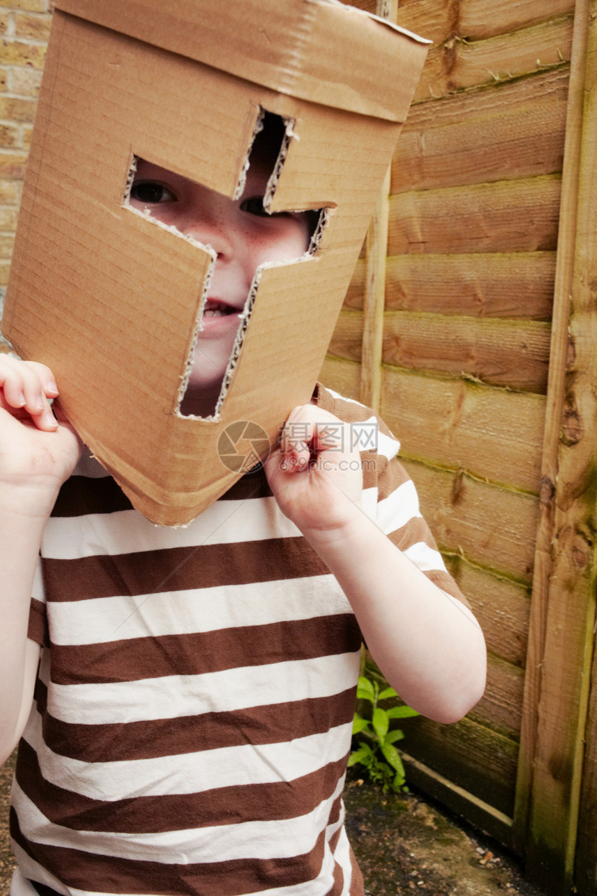 在户外佩戴纸板头盔的男孩图片
