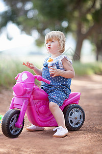坐在玩具摩托车上的女孩高清图片