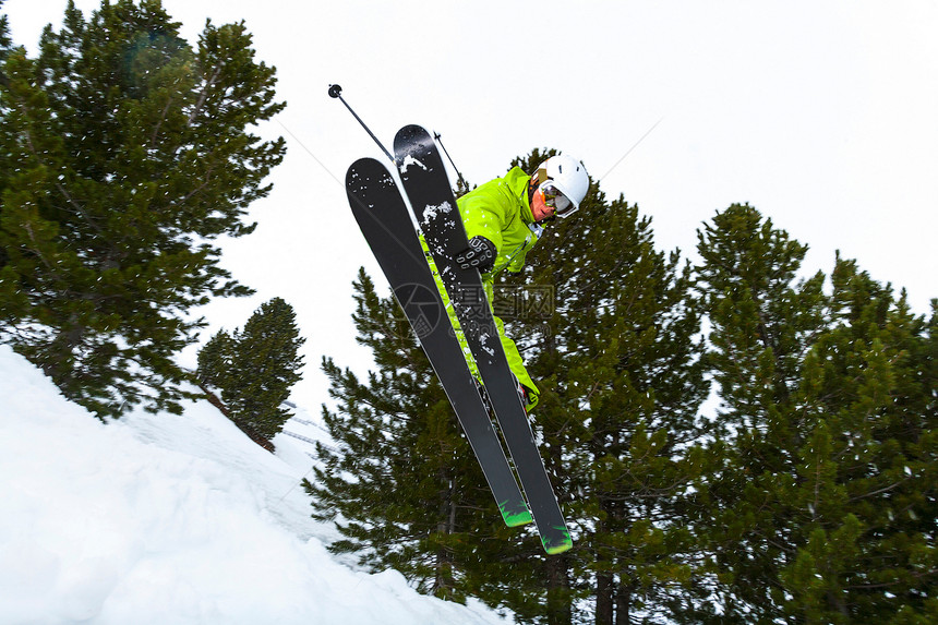 在雪坡上跳跃的滑雪者图片