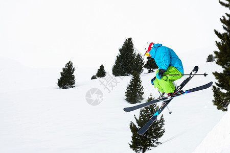 在雪坡上跳的滑雪者图片