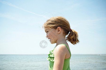 微笑的女孩站在沙滩上背景图片