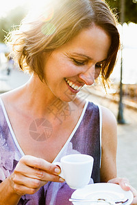 在室外喝咖啡的妇女无忧无虑的高清图片素材