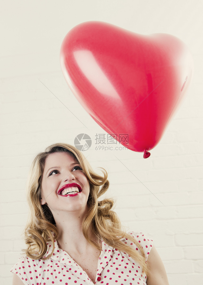 看着心形气球微笑的女人图片