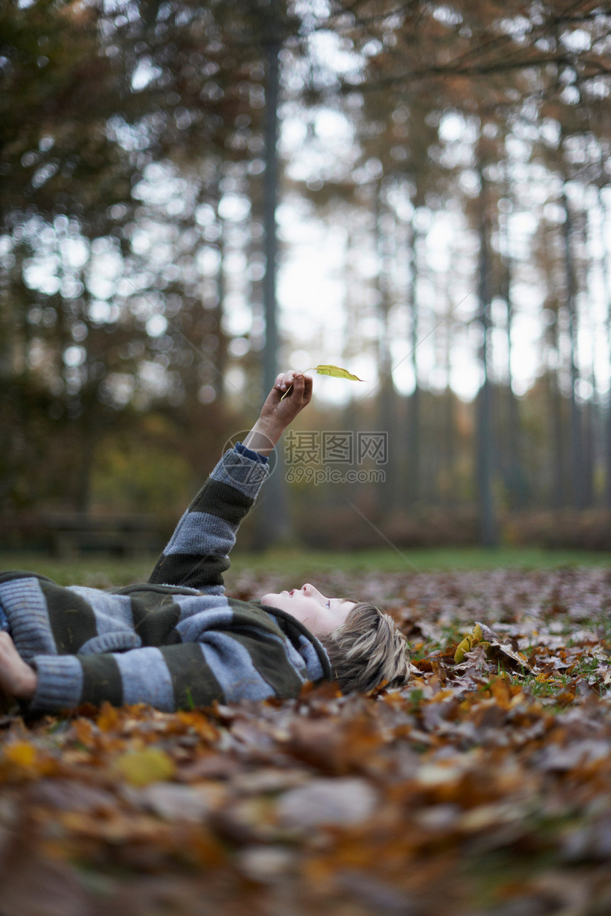 男孩躺在森林地面图片