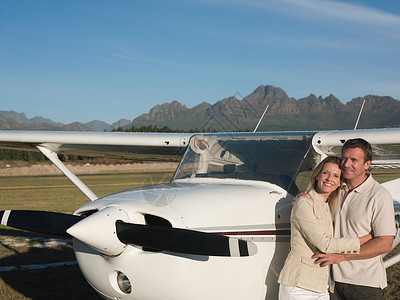 私人飞机前面的夫妻在拥抱图片