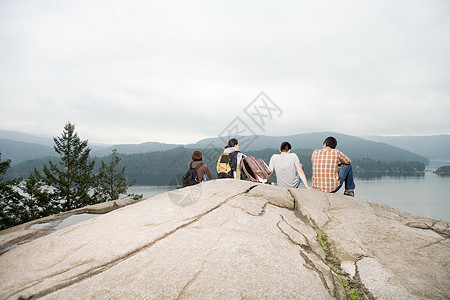 坐在湖边岩石上的人图片