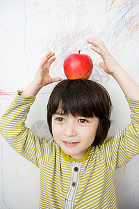 一个头上戴苹果的男孩图片