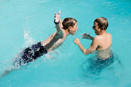 在游泳池玩耍的男孩图片
