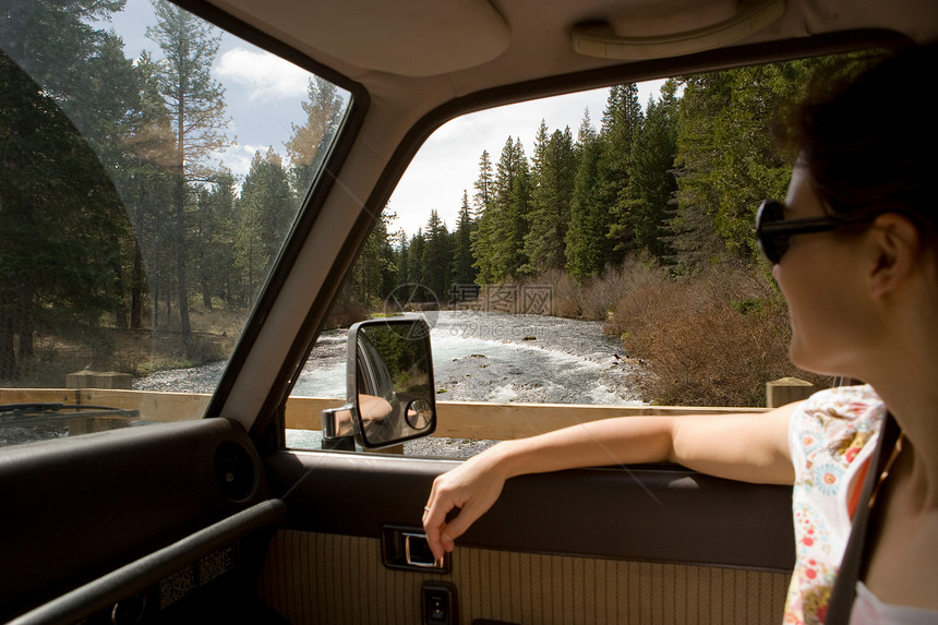 女人透过车窗看森林景色图片