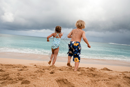 男孩女孩在沙滩上奔跑图片