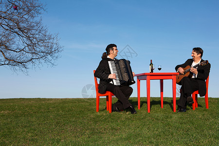 两个男人在户外玩手风琴和吉他背景图片