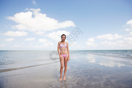 站在浅海的年轻女子肖像海岸高清图片素材