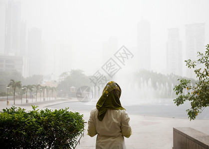 等待雨结束的年轻妇女图片