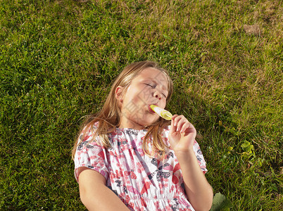女孩在草坪上吃冰棒图片