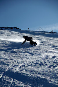 滑下雪坡的滑雪板运动员图片