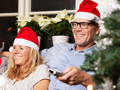 在沙发上戴圣诞帽子的成熟夫妇图片