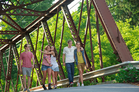 一群在桥上行走的朋友微笑高清图片素材