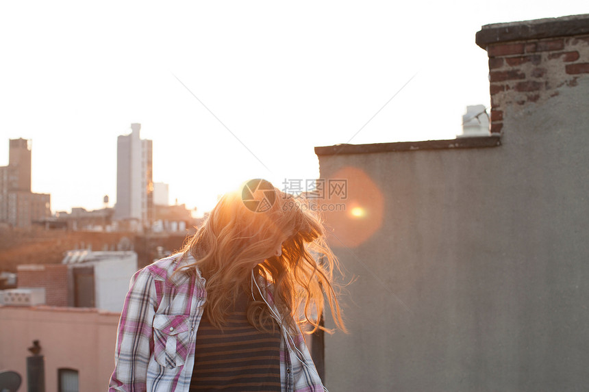 女青年在城市屋顶上发抖图片