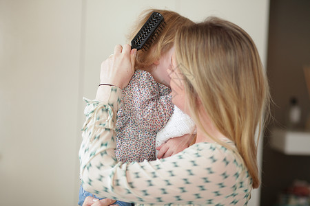 母亲为女儿梳理头发背景图片