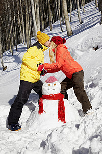 在雪人旁亲吻的情侣图片