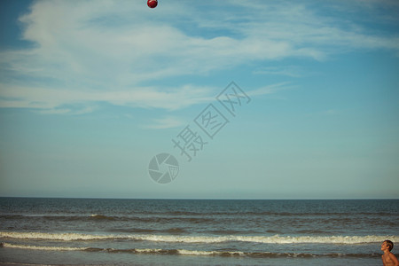 杰克逊维尔海滩男孩在海滩上玩球背景