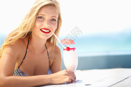 穿着比基尼在户外喝热带饮料的年轻女性信心高清图片素材