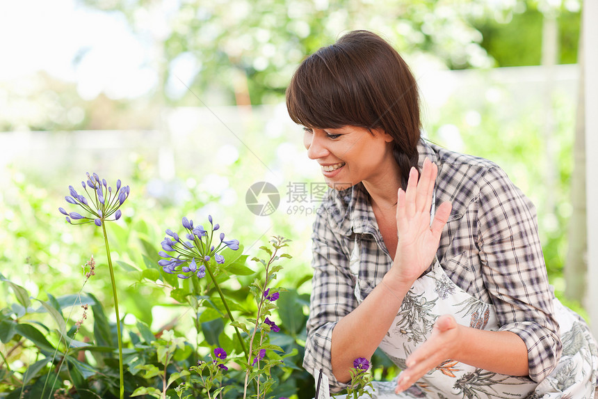 花园中的妇女检查植物图片