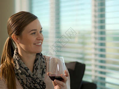 端着酒杯的女人在笑放松高清图片素材
