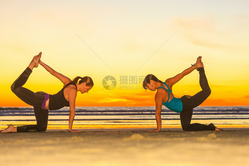 年轻女性在海滩上做瑜伽图片