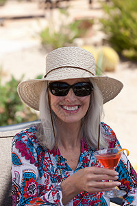 在户外喝鸡尾酒的老年妇女帽子高清图片素材