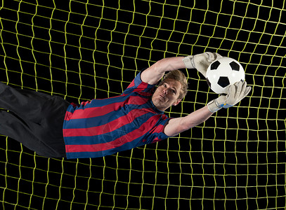 扑救足球运动员在空中抓球背景