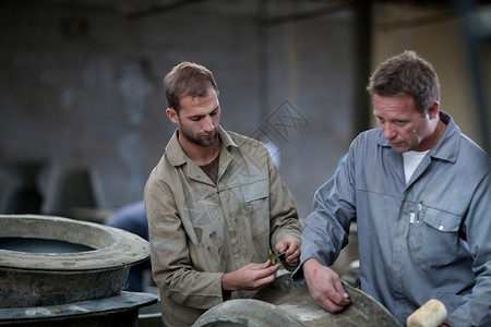在陶瓷厂检查模具的工人圆的高清图片素材