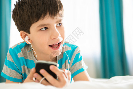 男孩在床上听MP3播放器图片