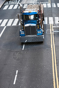 在城市街道驾驶的蓝色卡车图片