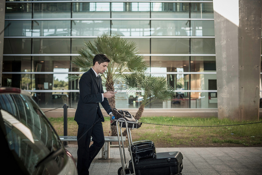 青年男子在机场使用行李推车图片