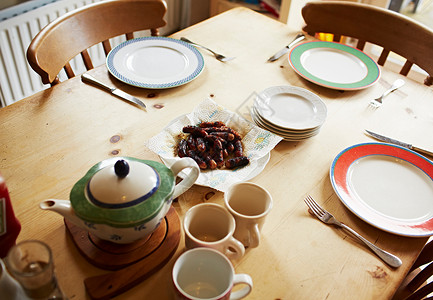 茶壶杯子和板放在木制桌上图片