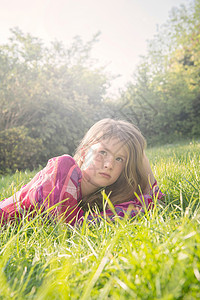 女孩躺在夏天的田地上图片
