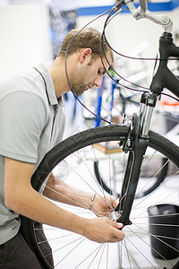 修理自行车的青年男子技巧高清图片素材