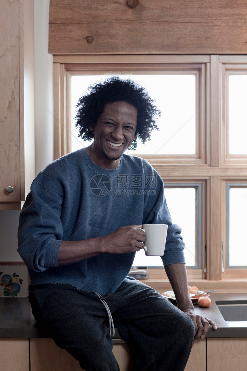成熟男人拿着杯子在厨房微笑 图片