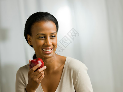 年轻女人拿着苹果微笑 图片