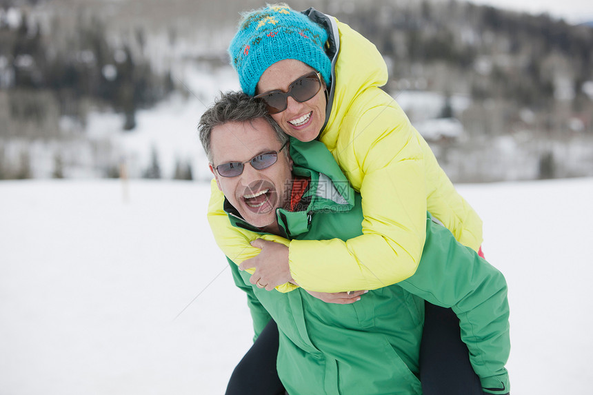 男子背着女人在雪地里面行走欢笑图片