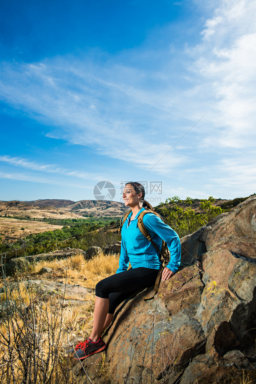坐在岩石上的女徒步者图片